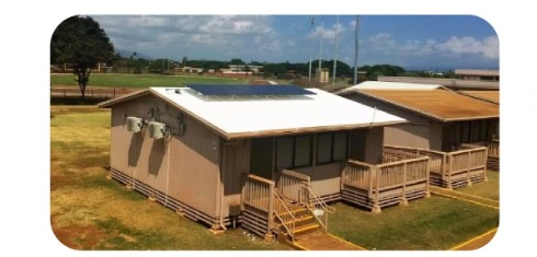 Building with rooftop solar panels and outdoor air conditioner units